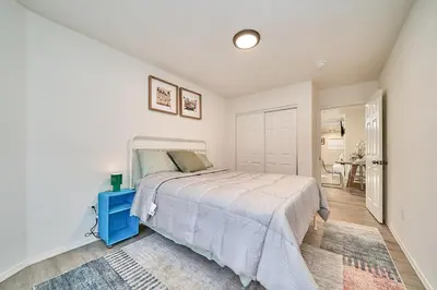 a bedroom with a large bed with a blue night stand at 4 bedrooms in Long Beach