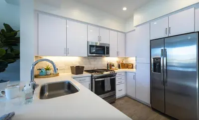 a kitchen with white cabinets and a stainless steel refrigerator at Santa Monica 3BD Serenity Suite with FREE PARKING in Los Angeles