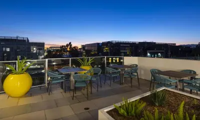 a patio with tables and chairs on a roof at Santa Monica 3BD Serenity Suite with FREE PARKING in Los Angeles
