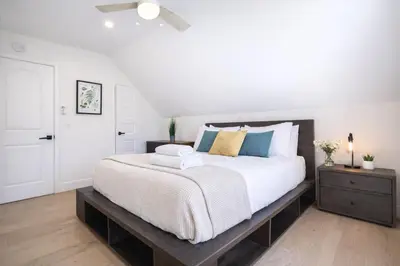 a bedroom with a large bed and a wooden floor at Modern 3BR Home Near USC, Museums & Coliseum in Los Angeles