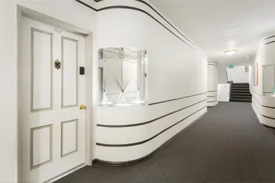 a hallway with a white and black stripe wall at Beverly Grove Hotel in Los Angeles
