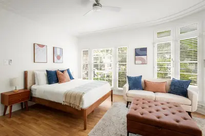 a white bedroom with a bed and a couch at Beverly Grove Hotel in Los Angeles