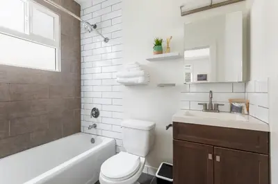 a bathroom with a toilet and a sink and a tub at Beverly Grove Hotel in Los Angeles