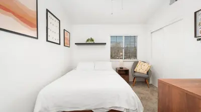 a white bedroom with a bed and a desk at Heidi House Entire Duplex Relocation Stays in Redlands