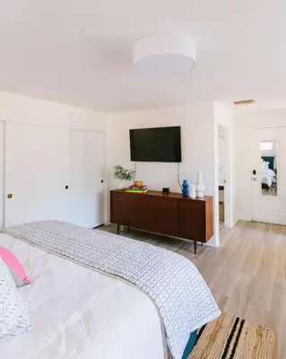 a bedroom with a bed and a flat screen tv at Heidi House Entire Duplex Relocation Stays in Redlands