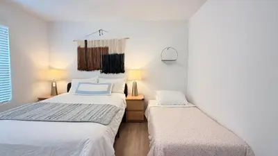 two beds in a room with white walls at Modern Luxury House 3B&4B House 30 mins DTLA in Baldwin Park