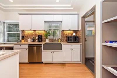 a kitchen with white cabinets and a sink at The SOFI Special - Modern Retreat, Dog Friendly in Los Angeles