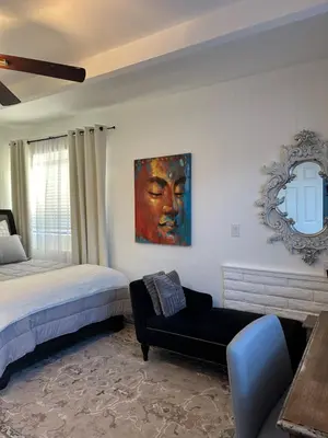 a bedroom with a bed and a couch and a mirror at San Pedro Delight in San Pedro Peninsula Hospital Heliport