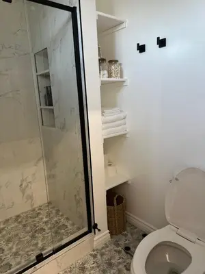 a bathroom with a toilet and a glass shower at San Pedro Delight in San Pedro Peninsula Hospital Heliport