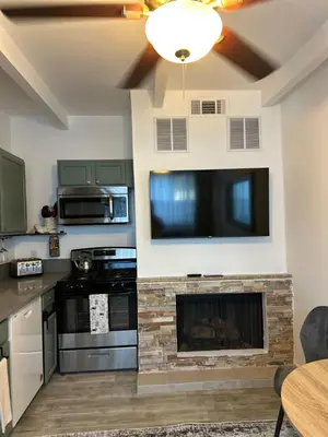 a living room with a fireplace and a flat screen tv at San Pedro Delight in San Pedro Peninsula Hospital Heliport