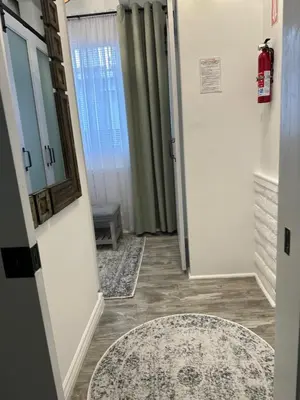 a hallway with a rug and a door with a window at San Pedro Delight in San Pedro Peninsula Hospital Heliport