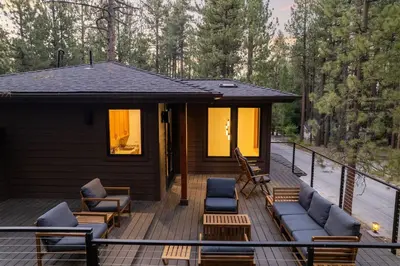 a cabin with a deck with couches and chairs at 34 - The Maple Crest home in Big Bear Lake