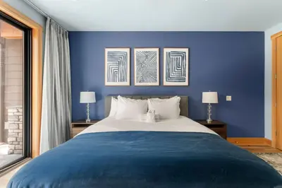 a blue bedroom with a large bed with two lamps at 34 - The Maple Crest home in Big Bear Lake