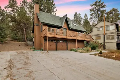 a large house with a deck on a driveway at Lakeview Pines Log Cabin #2585 in Big Bear Lake