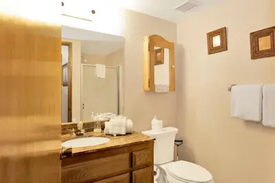 a bathroom with a toilet and a sink and a mirror at Summit Ski and Bike Trails #2574 in Big Bear Lake