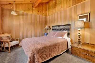 a bedroom with a bed and a chair in it at Slope Side Getaway #2526 in Big Bear Lake