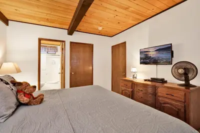 a teddy bear sitting on a bed in a bedroom at Switzerland Summit Condo #2569 in Big Bear Lake
