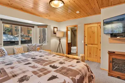 a bedroom with a bed and a flat screen tv at Golden West Cottage #2581 in Big Bear Lake