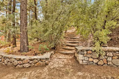 a stone path with a stone wall and trees at Arlberg Village Haus #2571 in Big Bear Lake