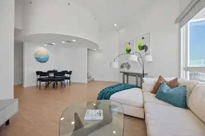 a living room with a white couch and a glass table at Waterfront Penthouse - Marina Views - Rooftop in Los Angeles
