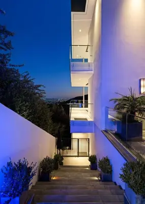a staircase leading up to a white building at night at Stunning Hollywood Villa Pool and Panoramic Views in Los Angeles