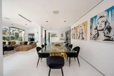 a dining room with a glass table and black chairs at Sunset Plaza Ultra Modern Home in Los Angeles