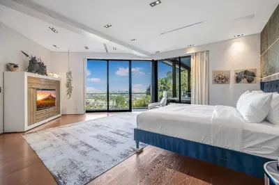 a bedroom with a large bed and large windows at Bali Inspired Villa in Sunset Plaza in Los Angeles