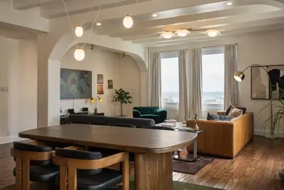 a living room with a wooden table and chairs at Ocean-View 1BR Condo in Historic Cooper Arms in Long Beach
