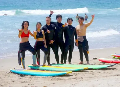a group of people standing on the beach with surfboards at Sapphire Marina - Marina View Pool, Gym, Game Room in Los Angeles