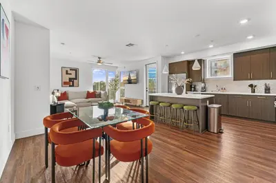 a kitchen and living room with a glass table and chairs at Sapphire Marina - Marina View Pool, Gym, Game Room in Los Angeles