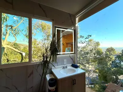 a bathroom with a sink and a large window at Serene Glasshouse Retreat with Iconic LA Skyline Views in Los Angeles