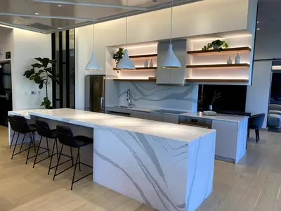 a kitchen with a large white island with bar stools at DTLA Luxury Studio in Los Angeles