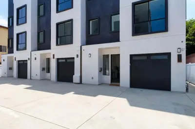 a large white building with four garage doors at Luxury Modern 4 Bed 4 Bath Home with Rooftop Deck #6 in Los Angeles