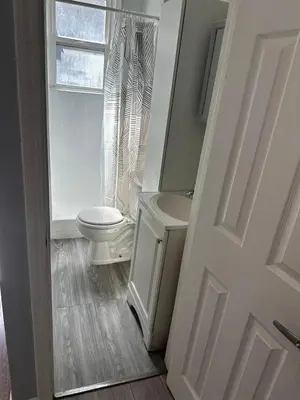 a white bathroom with a toilet and a window at Cozy Studio, Studio City Unit 2 in Los Angeles