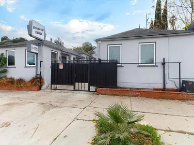 a white house with a black gate in front of it at Cozy Studio, Studio City Unit 2 in Los Angeles