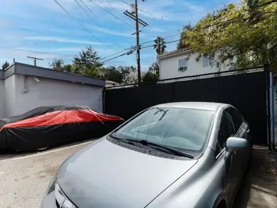 a silver car parked in a driveway next to a fence at Cozy Studio, Studio City Unit 2 in Los Angeles