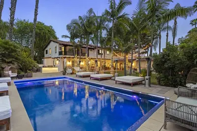a swimming pool in front of a house with palm trees at One of Kind Ultra Luxury Beverly Hills Estate in Los Angeles