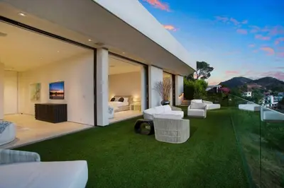 an outdoor patio with white furniture and green grass at Ultra-Luxurious BH Estate with Pool, Theatre, Views in Beverly Hills