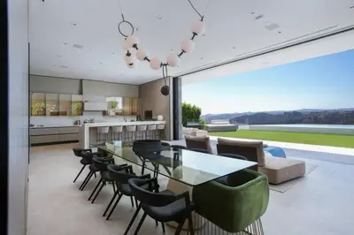 a kitchen and dining room with a glass table and chairs at Ultra-Luxurious BH Estate with Pool, Theatre, Views in Beverly Hills