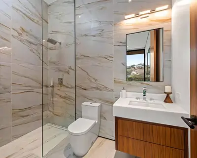 a bathroom with a toilet and a sink and a mirror at Luxurious 5BR Villa in BH with Pool, Theater, and Views in Los Angeles