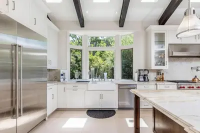 a kitchen with white cabinets and a large window at Summitridge Bev Hills Villa with Pool, Spa, Roof Deck in Beverly Hills