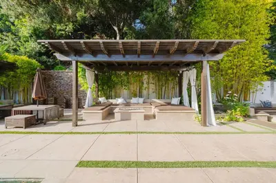 a pergola with couches and tables in a garden at Beverly Hills Ultra Luxury Villa with Pool and Theatre in Beverly Hills