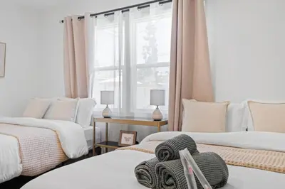 a room with three beds and a window at Pool House Retreat near LAX, SoFi & Beach in Inglewood