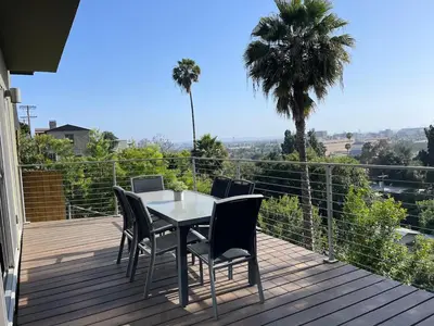 a table and chairs on a deck with a view at LA Chic Stunning Views & Sunsets in Los Angeles