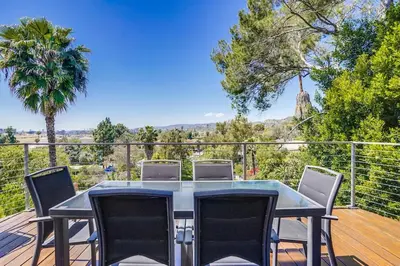 a patio with a table and chairs on a deck at LA Chic Stunning Views & Sunsets in Los Angeles