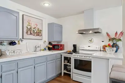a kitchen with white cabinets and a white stove top oven at Luxury LA Garden Estate Private Pool HotTub Tennis in La Habra