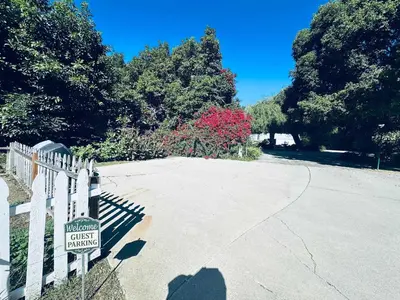 a parking lot with a sign on a fence at Luxury LA Garden Estate Private Pool HotTub Tennis in La Habra