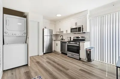 a kitchen with white cabinets and stainless steel appliances at Charming Modern apartment in Santa Monica in Los Angeles