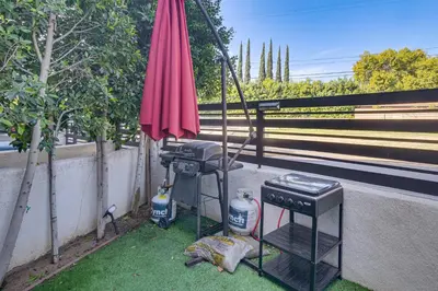 a grill and an umbrella on the side of a street at Work and Play! North Hills Studio 15 Mi to Hollywood in North Hills