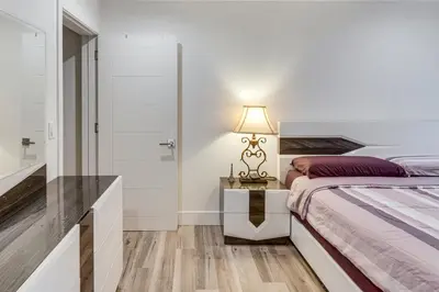 a bedroom with a bed and a table with a lamp at Work and Play! North Hills Studio 15 Mi to Hollywood in North Hills